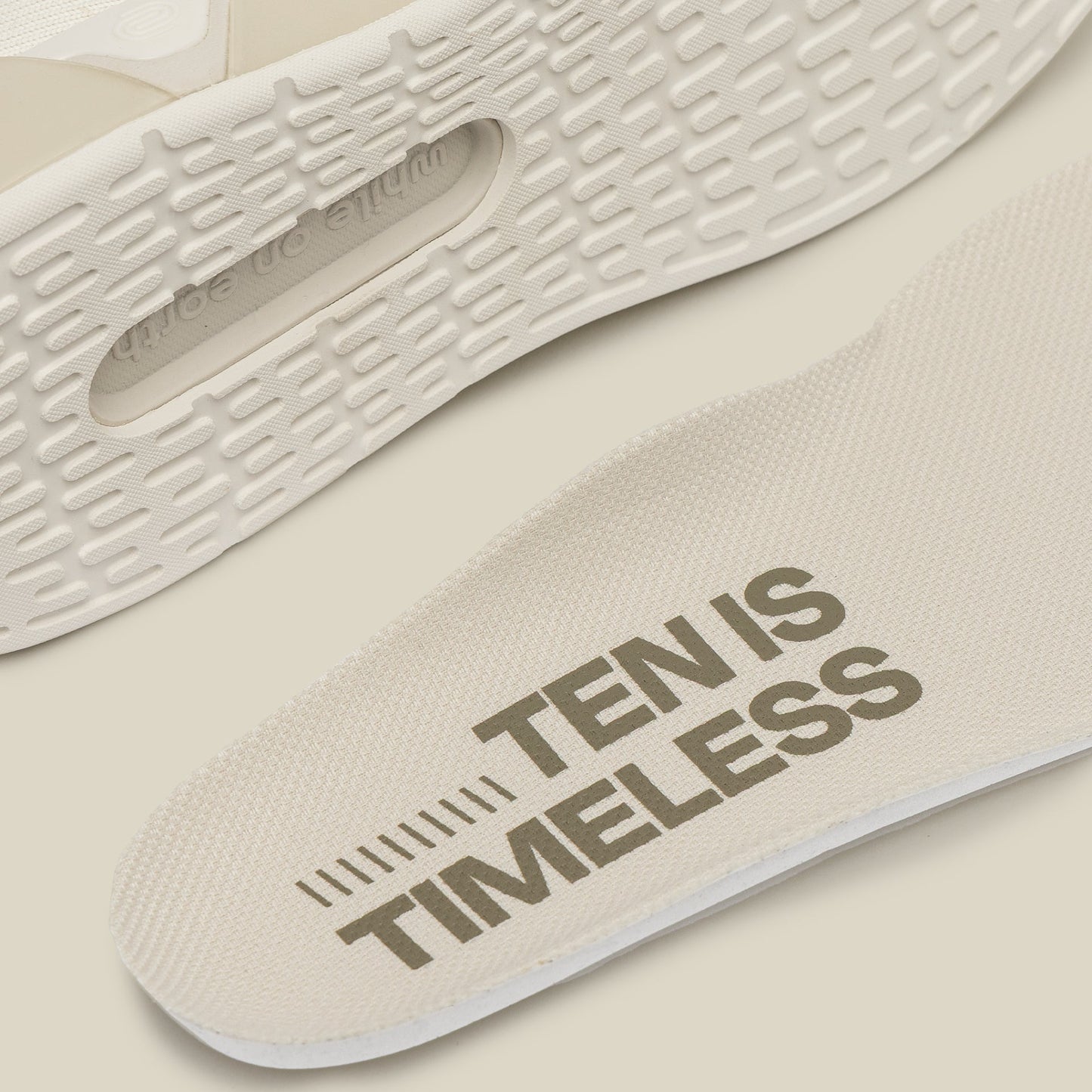 Close-up of a shoe sole with 'TEN IS TIMELESS' text on a beige background